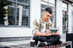Teen-Playing-Financial-Games-on-Cell-Phone