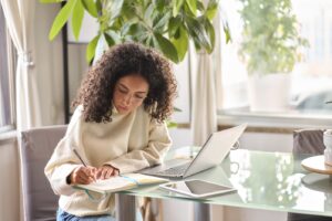 Woman-Watching-a-Credit-Union-Webinar-and-Taking-Notes